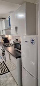 kuchnia z białymi szafkami i białą lodówką w obiekcie EDSPACE w mieście Abbey Wood