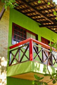 Chalé Verde في تامانداري: منزل أخضر مع شرفة مع نافذة