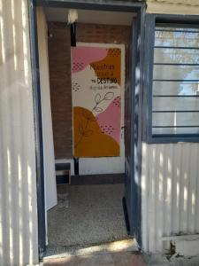 eine Tür zu einem Zimmer mit einem Plakat an der Wand in der Unterkunft Dormi familiar in Alta Gracia