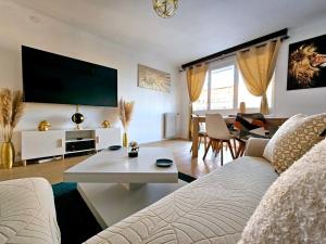 - un salon avec un canapé blanc et une télévision dans l'établissement Très bel Appartement, 10 min gare, 20 min de Paris, à Garges-lès-Gonesse