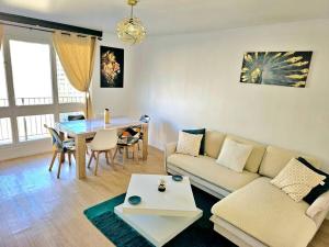 - un salon avec un canapé et une table dans l'établissement Très bel Appartement, 10 min gare, 20 min de Paris, à Garges-lès-Gonesse