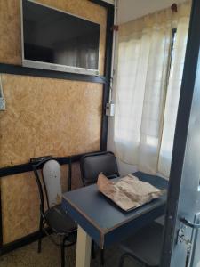 einen Tisch und einen Stuhl in einem kleinen Zimmer mit einer Mikrowelle in der Unterkunft Dormi familiar in Alta Gracia
