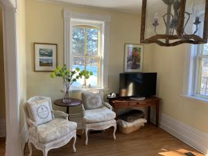 a living room with two chairs and a television at Foxingham Farm Bed & Breakfast in Mulmur