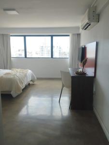 a bedroom with a bed and a desk with a television at HERMOSO MONOAMBIENTE A POCAS CUADRAS DEL RIO! in Rosario