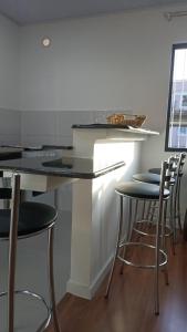 a kitchen with a counter with stools around it at RCM Vilas - Studio 103 Deluxe in Joinville