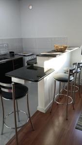 een keuken met een aanrecht met krukken eromheen bij RCM Vilas - Studio 103 Deluxe in Joinville