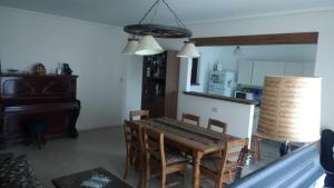 a dining room with a table and a kitchen at Habitación privada en Casa Musical I in Mar del Plata