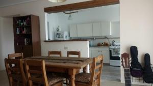 uma cozinha com uma mesa de madeira e cadeiras num quarto em Habitación privada en Casa Musical I em Mar del Plata
