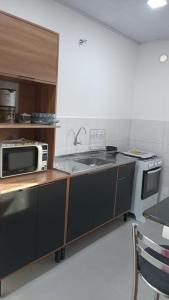 a kitchen with a sink and a microwave at RCM Vilas - Studio 103 Deluxe in Joinville