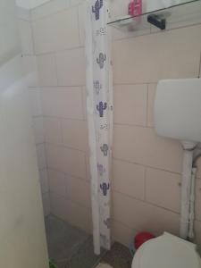 ein Bad mit einem WC und einem Duschvorhang in der Unterkunft Dormi familiar in Alta Gracia