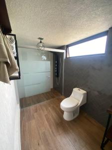a small bathroom with a toilet and a window at Cabaña del Lago in Ajijic