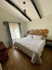 a bedroom with a large bed with a large wooden headboard at Cabaña del Lago in Ajijic