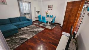 uma sala de estar com um sofá azul e uma mesa em Santa Luzia Apartment no Funchal