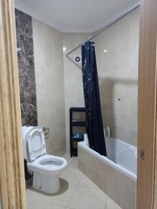 a bathroom with a toilet and a bathtub with a shower curtain at Superb flat near the Medina in Tangier