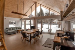 a kitchen and living room with a table and chairs at Casa Tinca 2 in Izvoru Mureşului