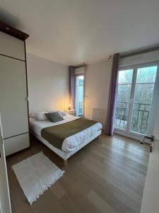 a bedroom with a bed and a large window at Disney 3 mn, 14 people , 4 bedrooms, 2 parkings privés in Chessy
