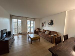 a living room with a couch and a table at Disney 3 mn, 14 people , 4 bedrooms, 2 parkings privés in Chessy