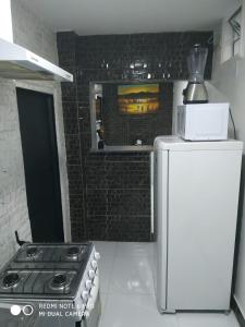 a small kitchen with a stove and a refrigerator at RESIDENCIAL ESPERANÇA in Teresina