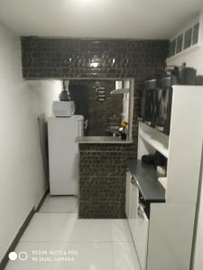 a kitchen with a white refrigerator and a brick wall at RESIDENCIAL ESPERANÇA in Teresina