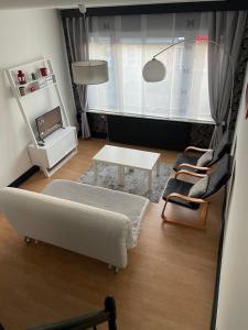 ein Wohnzimmer mit einem Bett, einem Tisch und Stühlen in der Unterkunft Duplex tout confort Menen in Menen