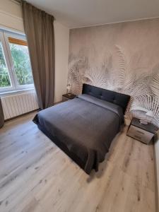 1 dormitorio con cama grande y ventana grande en Bilocale Villesse, 