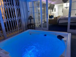 a large blue tub in a room with a bedroom at Apartment on 32 in Cape Town