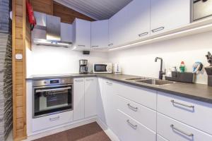 a kitchen with white cabinets and a sink at Rukan Talvihovit in Ruka