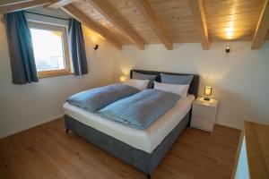 a bedroom with a bed with blue sheets and a window at Ferienwohnung Osterbach in Bad Feilnbach