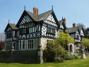 an old black and white house with a wall at Cosy North Wales 2 BEDROOM Chalet in Caernarfon