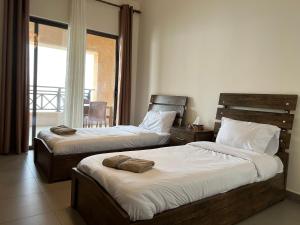 two beds in a hotel room with a balcony at EP4 Samarah Resort in Sowayma