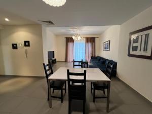 a dining room and living room with a table and chairs at EP4 Samarah Resort in Sowayma