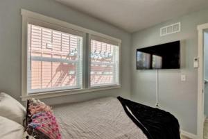 a bedroom with two windows and a bed and a television at 5787 Coffey Villa Perfect for Traveling Professional in Garden City