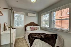 a bedroom with a bed and two windows at 5787 Coffey Villa Perfect for Traveling Professional in Garden City