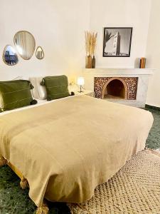 1 dormitorio con 1 cama grande y chimenea en Riad Ksar Saad & Spa en Marrakech