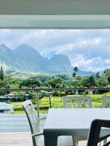 Moorea villa neuve, vue panoramique - Painapo Lodge Ho'e في Paopao: طاولة وكراسي مطلة على الجبال