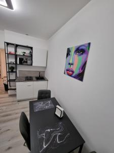 Cette chambre dispose d'une table et d'une peinture murale. dans l'établissement Bilocale Villesse, 