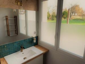 La salle de bains est pourvue d'un lavabo et d'une fenêtre. dans l'établissement Maison 8 personnes loisirs ou travail campagne ville, à Château-Gontier