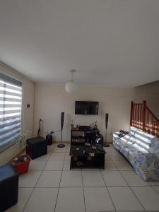 a living room with a couch and a tv at Casa amplia turistas 7 personas in La Serena