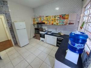 uma cozinha com um jarro de água azul num balcão em Quarto no centro de Londrina, TV, ventilador e wifi em Londrina