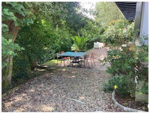 un patio con mesa y sillas en un jardín en Mendiska, en Bayona