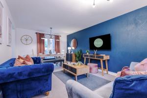 un soggiorno con 2 sedie blu e una parete blu di Beautiful Stoke Home Sleeps 10 by PureStay Short Lets a Stoke on Trent