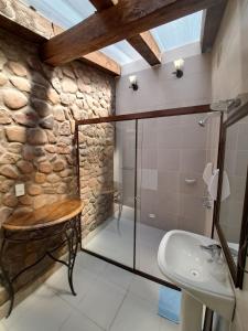 a bathroom with a glass shower and a sink at Hotel Santa Mónica in Potosí