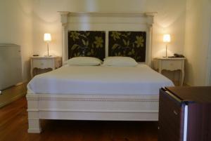 a bedroom with a white bed with two lamps at Hotel Rural Villa Julia in Vila Flor