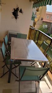 a table and chairs on a balcony with a spider on the wall at la palme d or in Saint-Raphaël