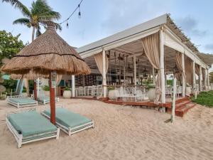 a resort with chairs and umbrellas on the beach at Villa Familiar con Alberca Privada en Tulum Country Club Riviera Maya in Akumal