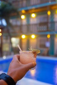 une main tenant un verre à la chaux dans l'établissement Ocean Tide Beach Resort, à San Pedro