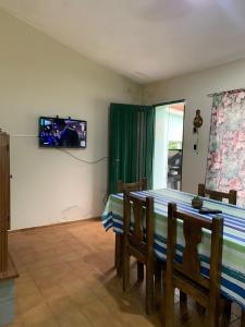 a dining room with a table and a television on a wall at Chalet MAX in Bialet Massé