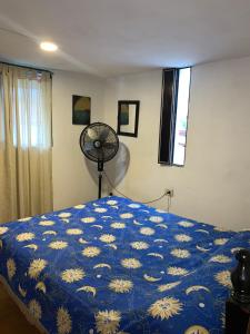 a bedroom with a bed with a blue comforter and a fan at Chalet MAX in Bialet Massé +8 photos