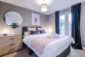 a bedroom with a large bed and a mirror at Beautiful Stoke Home Sleeps 10 by PureStay Short Lets in Stoke on Trent