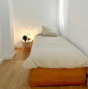 een slaapkamer met een bed met een witte sprei bij Maravilloso apartamento en el centro in Ceuta